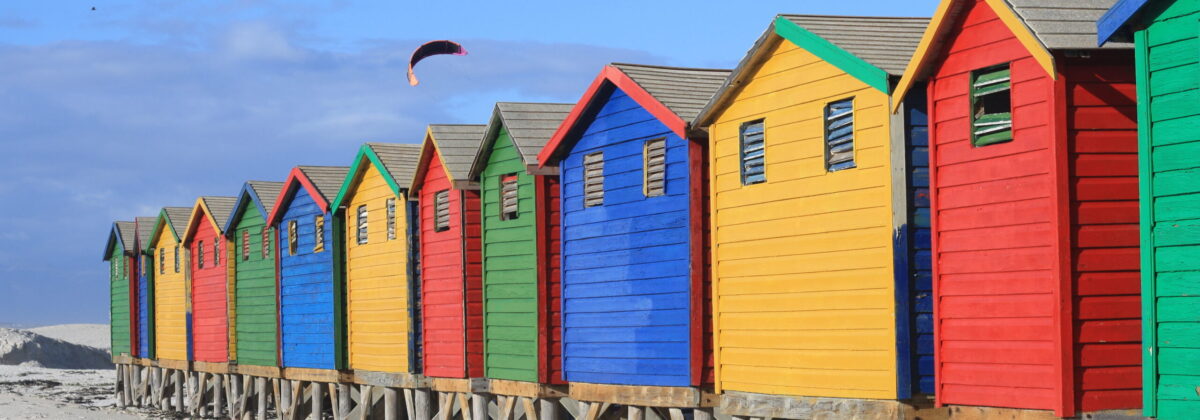 a row of colorful houses on the beach