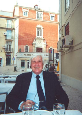 Frank Dutra at an outdoor restaurant in front of a couple buildings