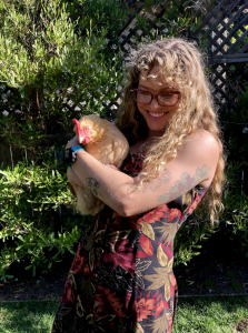 Woman in a dress holding a chicken