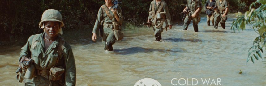 6 people in camoflauge uniform wading in a river. UCSB Cold War Working Group